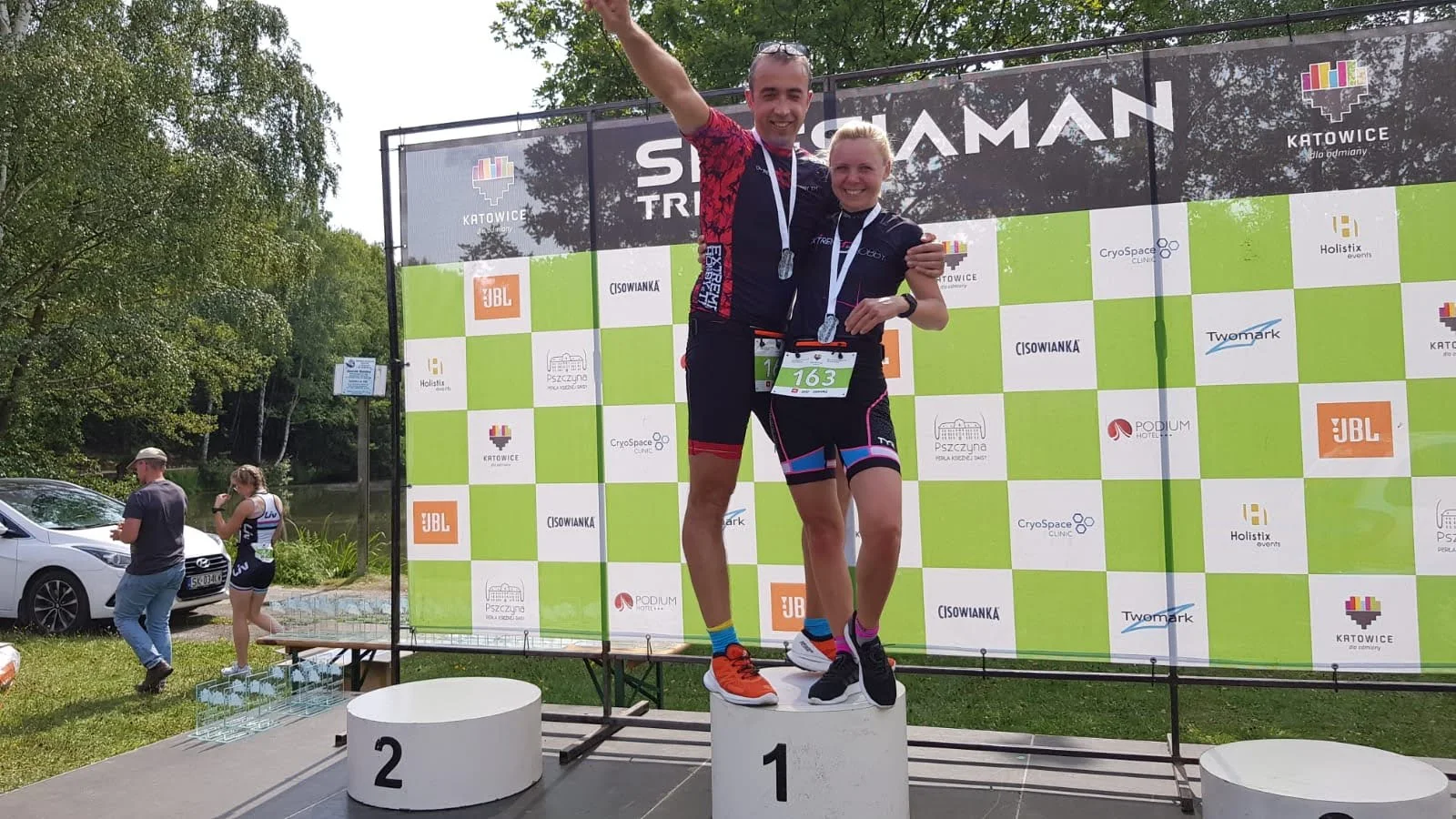 Mariusz Cyman z medalem na podium zawodów triathlonowych
